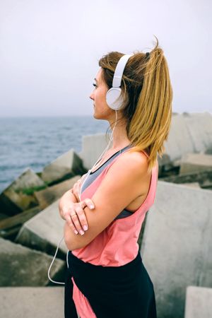 Sportswoman with headphones watching the sea