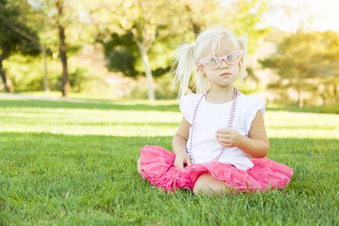 Little Girl Playing Dress Up With Pink Glasses and Necklace