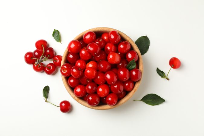 Bowl with fresh red cherry on plain background, top view