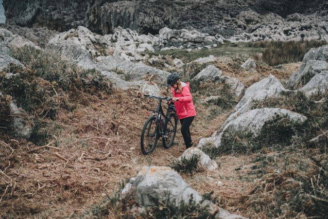 Anonymous female bicyclist on rocks