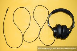 Headphones and cord on yellow background 0yX6lq