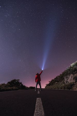 Traveler standing with torch at starry night