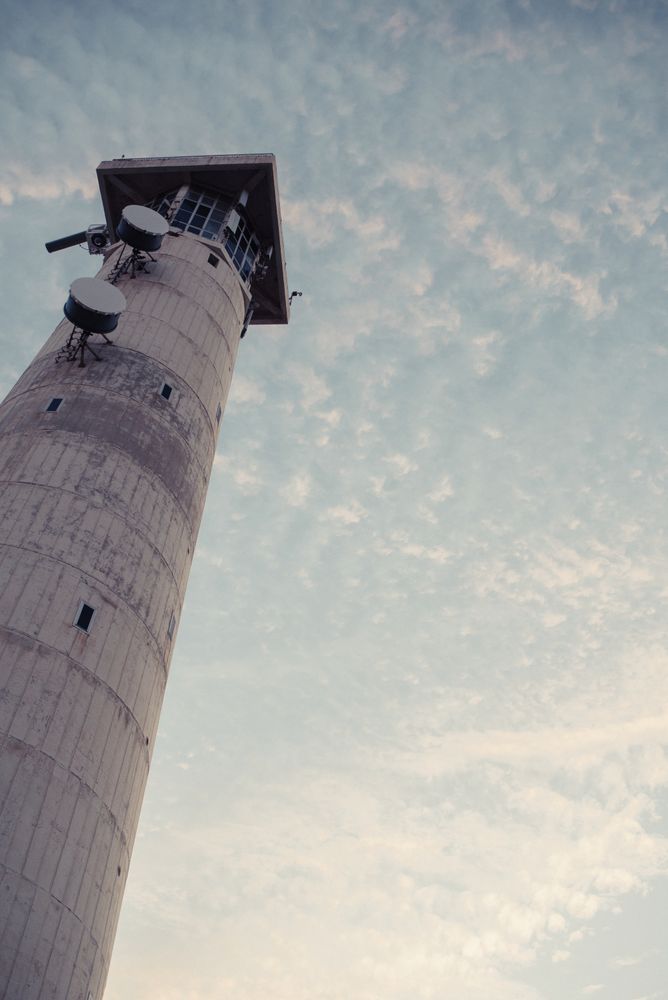 Round grey lighthouse tower rising up to sky