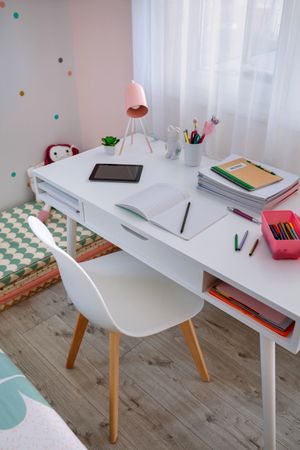 Desk in girl's bedroom decorated in pastel colors