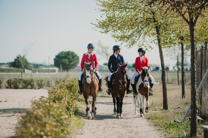 Young horse riders on pathway in nature