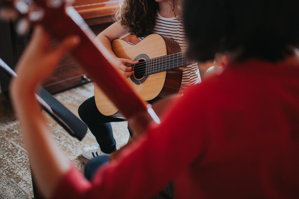Close up of female student strumming guitar