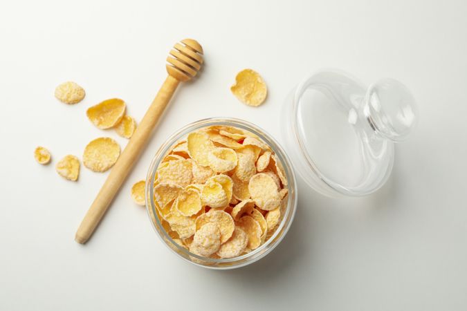 Dipper and jar of muesli on plain background