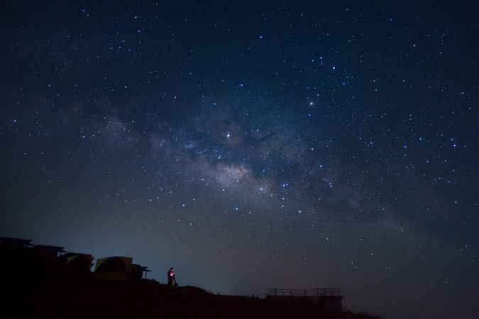 Landscape with milky way, Night sky with stars and silhouette of a standing man on Phutabberk Phetchabun in Thailand