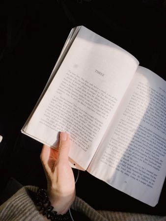 Cropped image of hand holding an open book