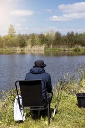 fishing rod on lake water background. Man catching fish by spinning on lakeside