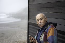 Older man with smartphone in remote village