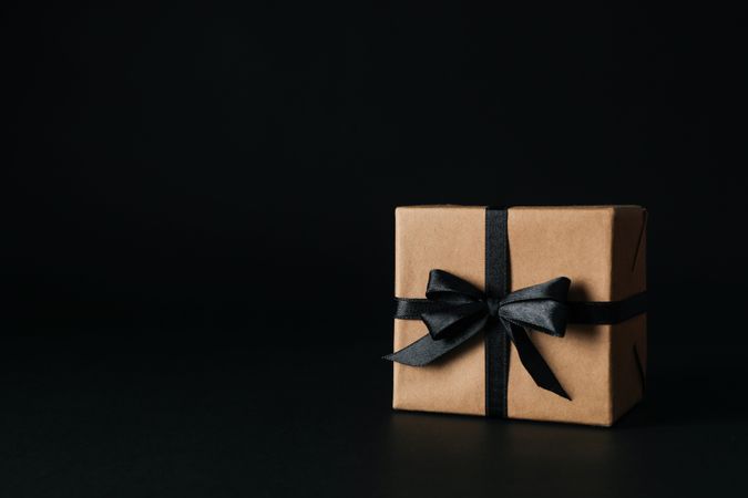 Gift box with dark bow on dark background