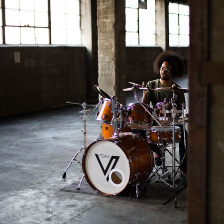 Smiling man playing drums in spacious garage