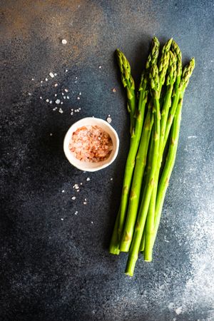 Bunches of raw asparagus on counter with Himalayan salt