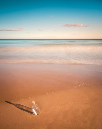 Bottle in sand near sea