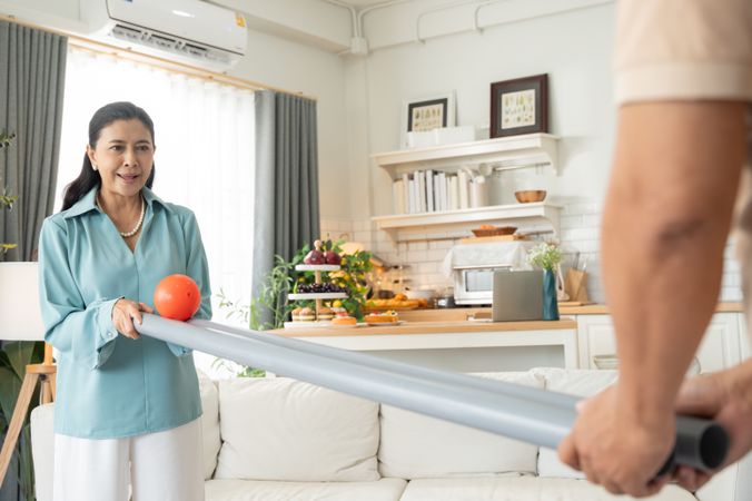 Mature woman playing rolling ball for practice balance and concentrate at home