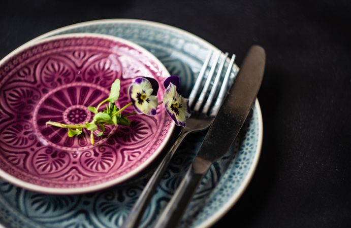 Spring table setting with delicate purple flowers on patterned plate