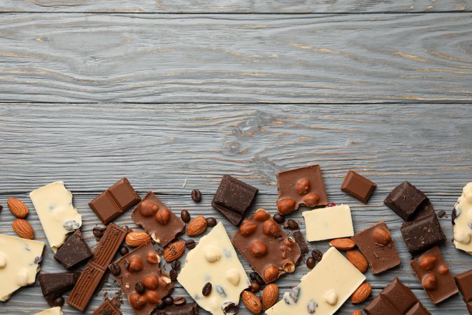 Different chocolate on gray wooden background, top view