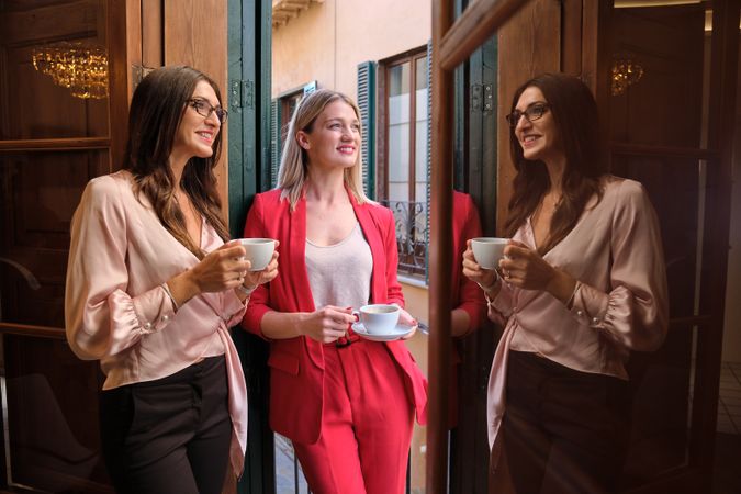 Smiling women drinking coffee together