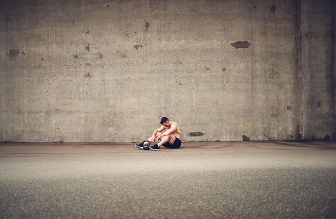 Fit man sitting in large concrete room