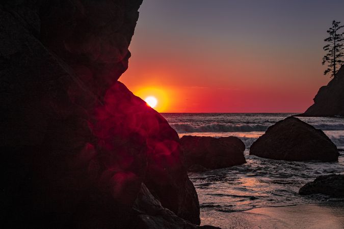 Sunset seen behind cliffs of rocky beach