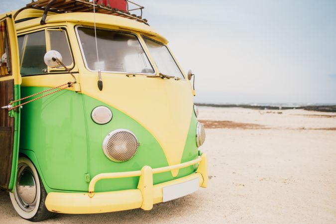 Bright retro minibus with round headlights on beach