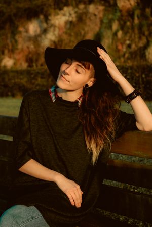 Stylish young woman in felt hat outdoors
