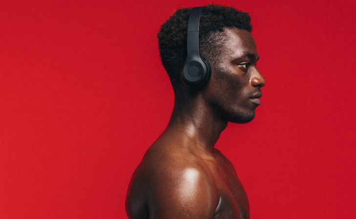 Fit man listening music with headphones during workout session