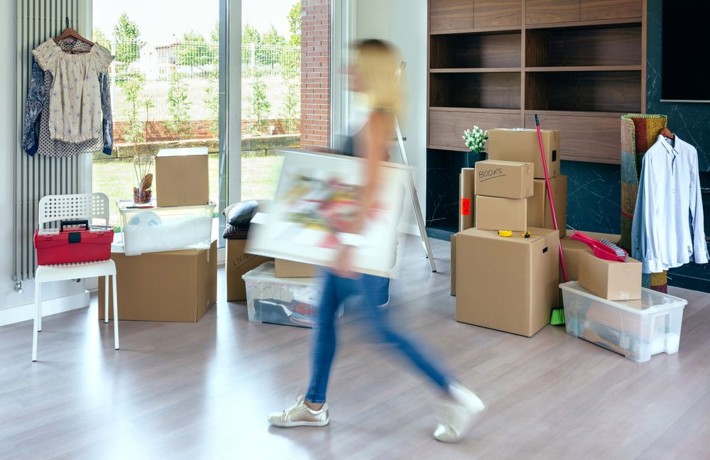 Woman carrying painting at home