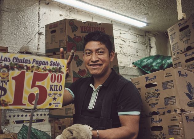 Man among fruit boxes in store in Mexico City