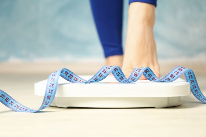Woman stands on the scales. Measuring tape. Weight loss