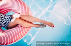 Woman sitting in inflatable ring in a pool 1bEBN0