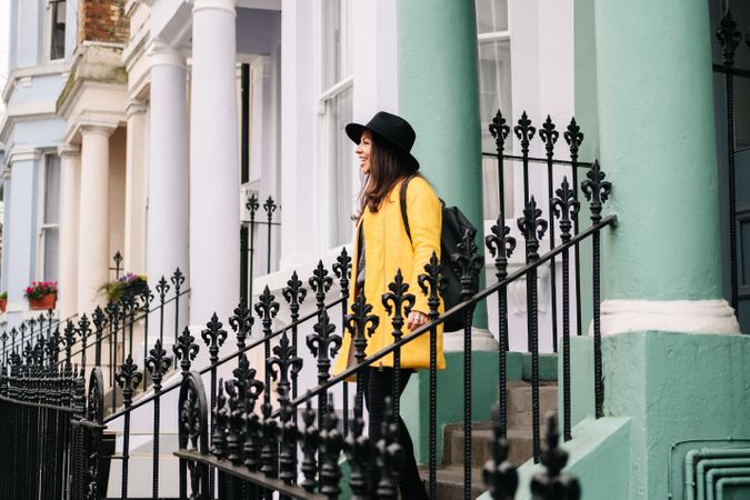 Cheerful woman standing in stairs in typical london buildings