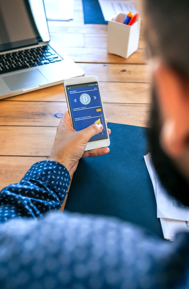 Businessman looking mobile with bitcoins information