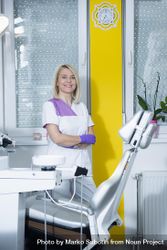 Female dentist in purple gloves in bright modern office 5lMlo4