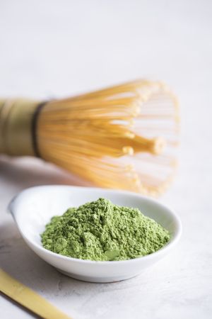Green matcha tea powder and bamboo whisk