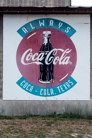 Old Coca-Cola sign on a building in Pipe Creek, a small community in Bandera County, Texas