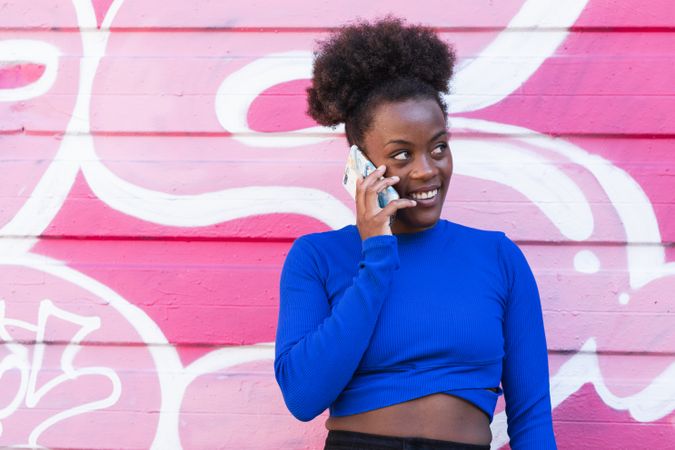 Content Black woman speaking on smartphone in city