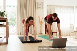 Couple exercising at home following instructions on laptop 49A864