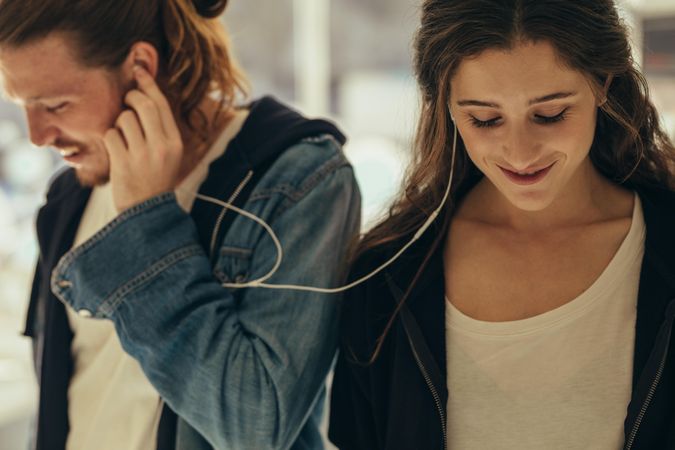 Happy couple listening to music sharing earphones