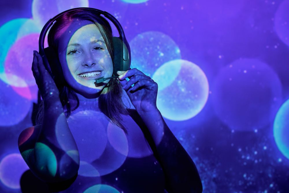 Cheerful woman with headset under colorful illumination