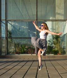 Female in skirt joyfully leaping in the sun