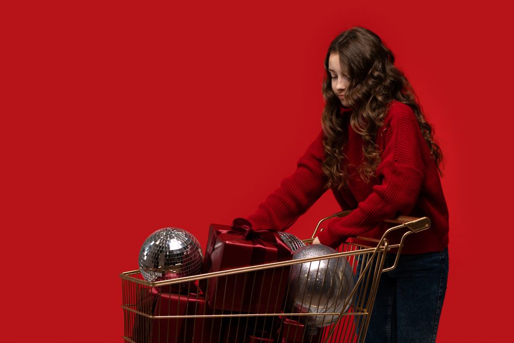 Girl pushes shopping cart full of gifts and disco balls