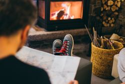 Man reading by the fireplace