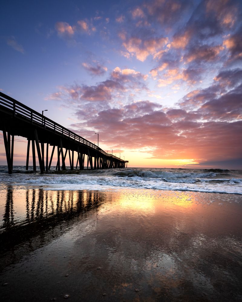 Brown fishing pier on sea during cloudy sunset