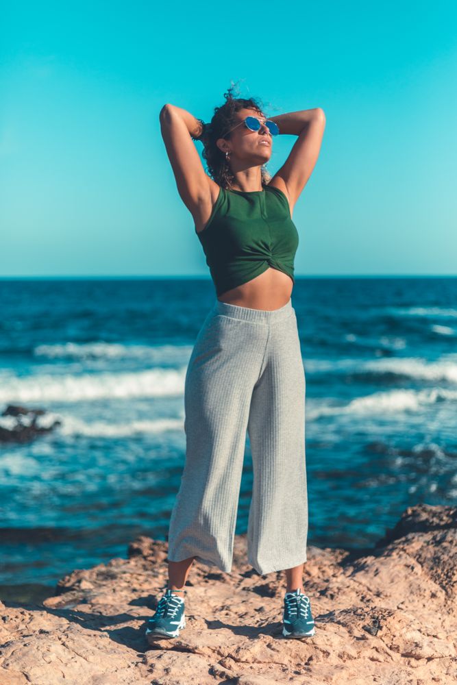 Stylish woman standing near sea