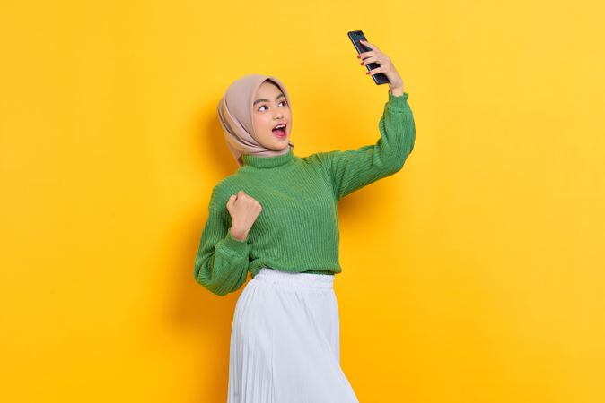 Woman in headscarf taking selfie with smart phone