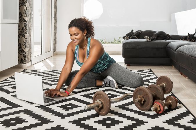 Woman using laptop to do her workout at home