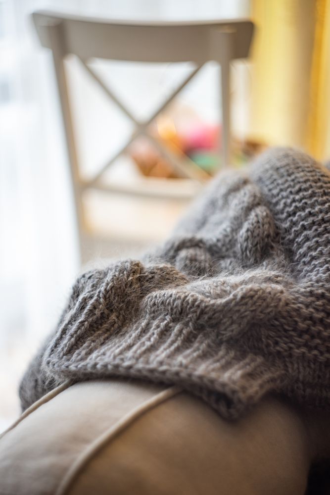 Close up of vintage knitting sweeter on a sofa in living room