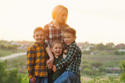 Happy mother and sons at dusk together